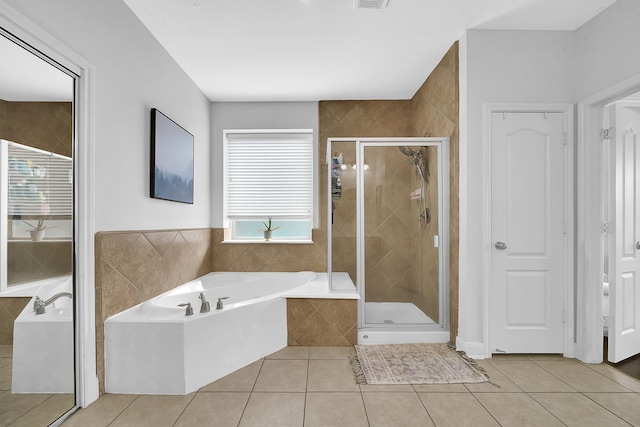 bathroom with tile patterned flooring and separate shower and tub