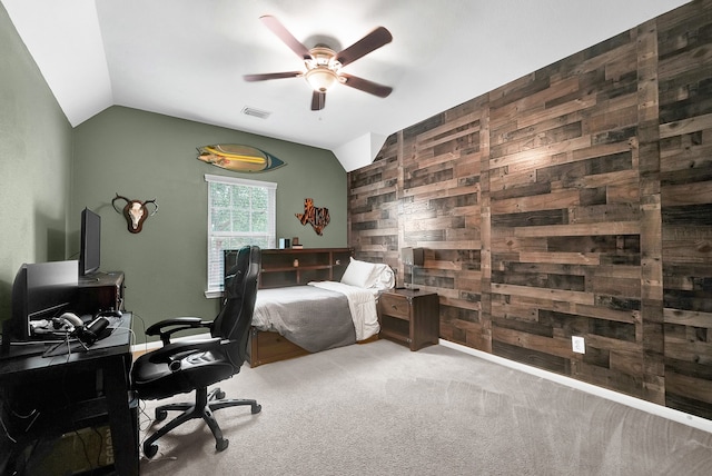 carpeted bedroom featuring ceiling fan, vaulted ceiling, and wooden walls