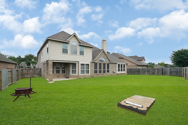 rear view of property featuring a lawn