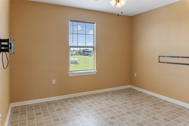 spare room with ceiling fan and light tile patterned floors