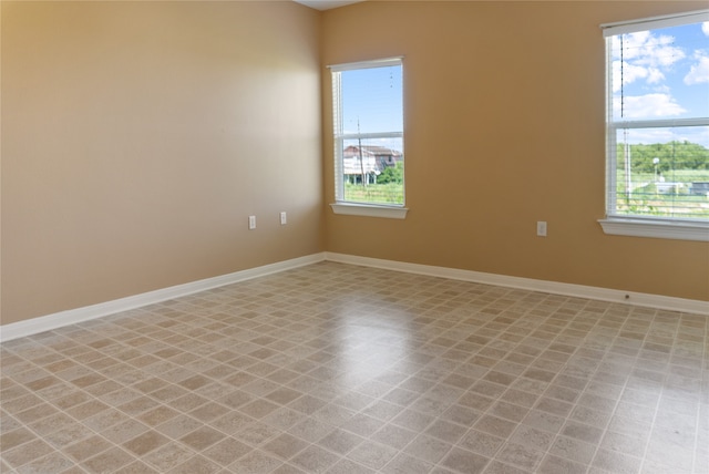 tiled empty room featuring plenty of natural light