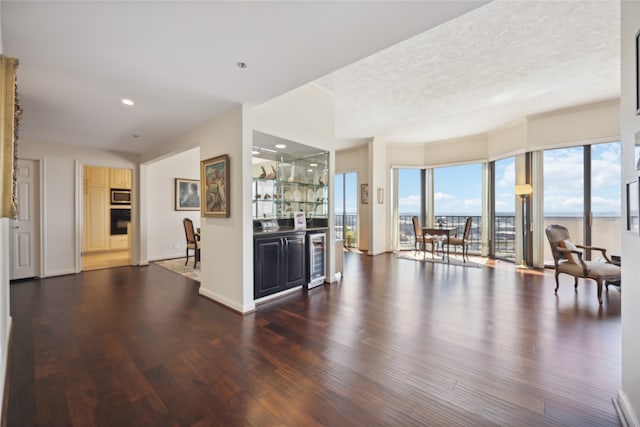 kitchen with beverage cooler, dark wood-type flooring, and a textured ceiling