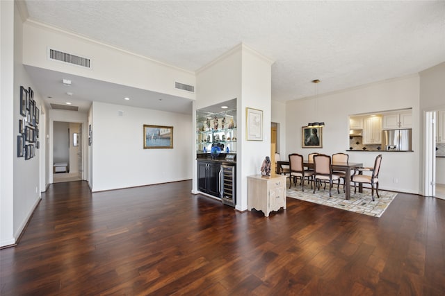 living room with wine cooler, dark wood-type flooring, a textured ceiling, and crown molding