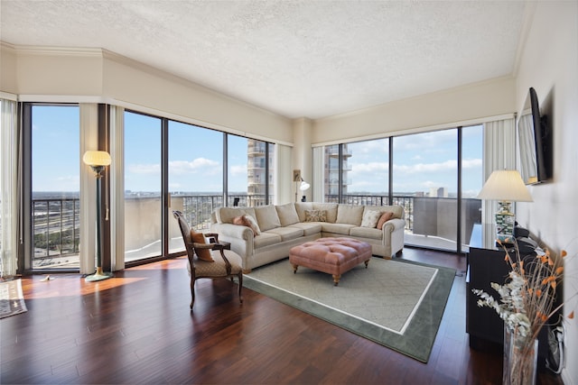 living room featuring hardwood / wood-style flooring, a textured ceiling, and ornamental molding