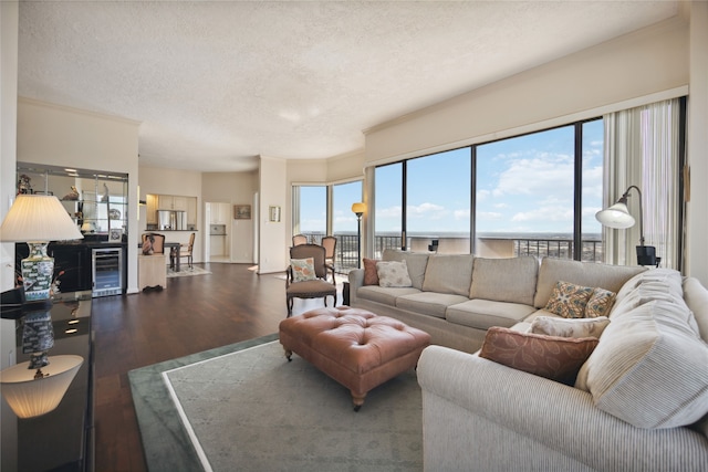 living room with a textured ceiling, ornamental molding, dark hardwood / wood-style floors, and beverage cooler