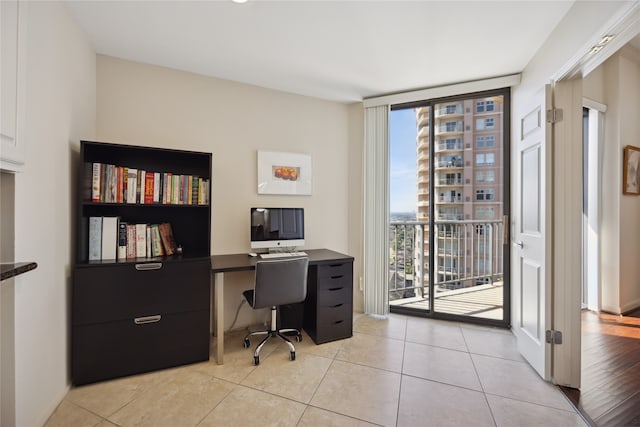 office area featuring light tile patterned floors and a wall of windows