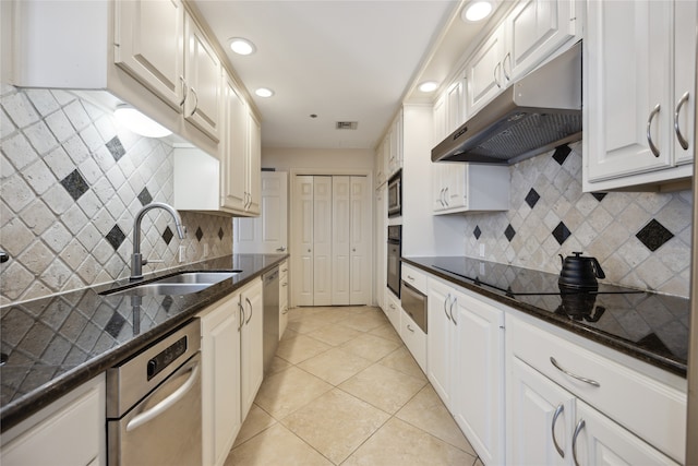 kitchen with sink, dark stone countertops, white cabinetry, and backsplash