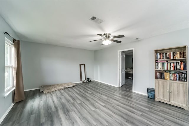 unfurnished room with wood finished floors, visible vents, and baseboards