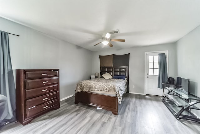 bedroom featuring visible vents, ceiling fan, baseboards, and wood finished floors