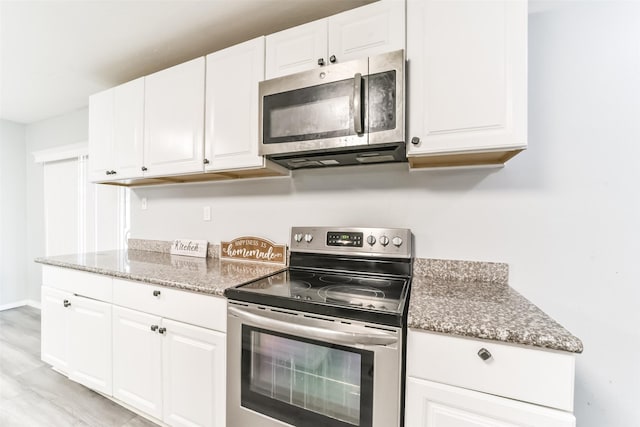 kitchen featuring light stone countertops, appliances with stainless steel finishes, and white cabinets