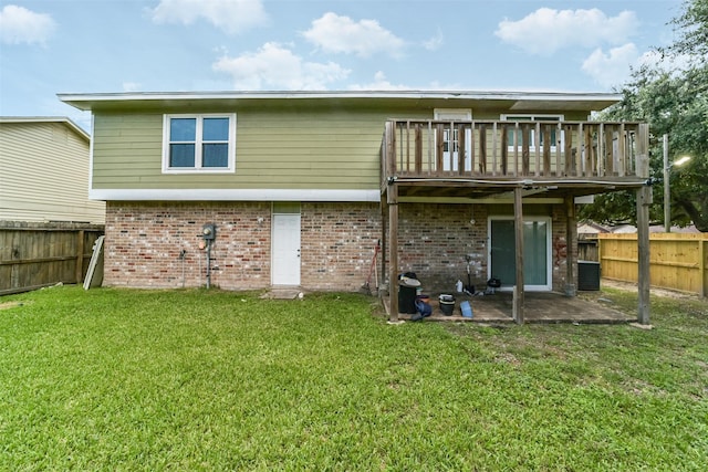 rear view of property featuring a patio, a fenced backyard, a yard, a wooden deck, and brick siding