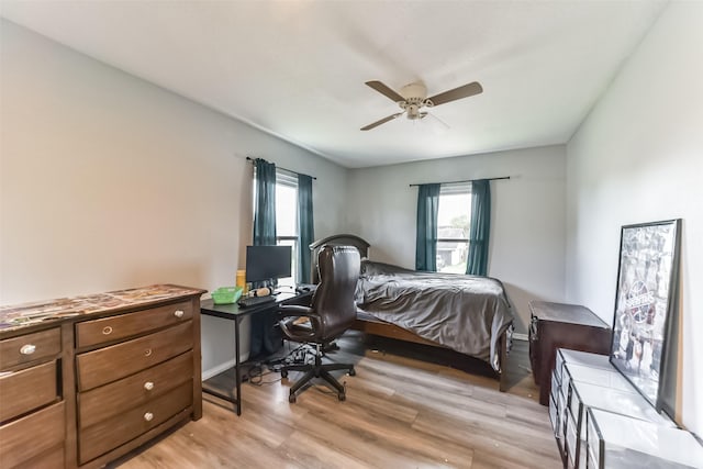 bedroom with ceiling fan, light wood-type flooring, and baseboards