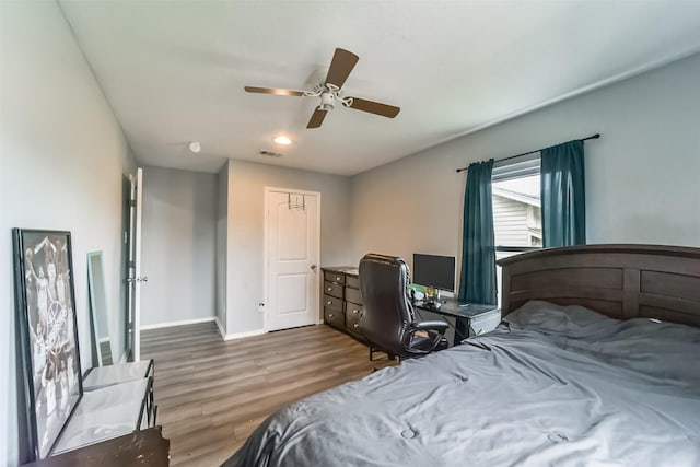 bedroom with baseboards, visible vents, ceiling fan, and wood finished floors