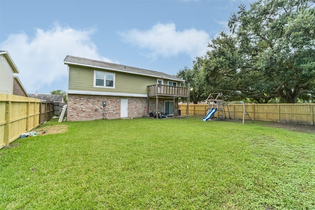 rear view of house featuring brick siding, a lawn, a playground, and a fenced backyard