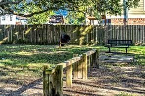 view of community featuring a yard and fence