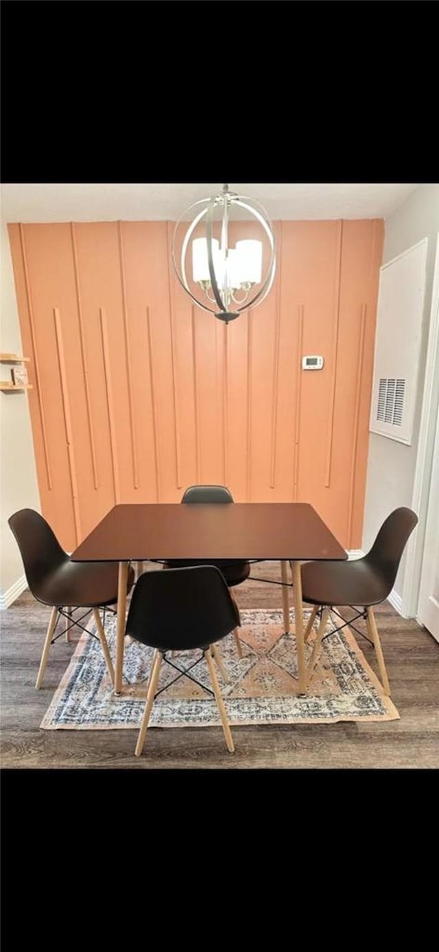 dining space with a notable chandelier, baseboards, and wood finished floors