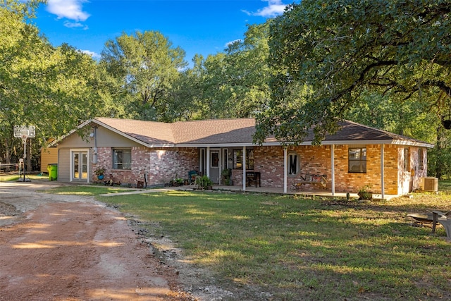 130 Green Acres Loop, Bastrop, TX 78602 - ranch-style house with dirt driveway, brick siding, and a front yard