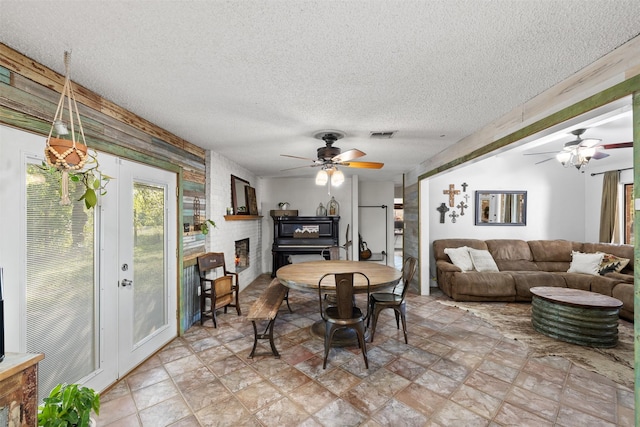 130 Green Acres Loop, Bastrop, TX 78602 - dining space featuring a textured ceiling, ceiling fan, visible vents, and a brick fireplace