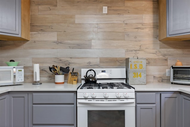 130 Green Acres Loop, Bastrop, TX 78602 - kitchen featuring light countertops, gray cabinets, decorative backsplash, and white appliances