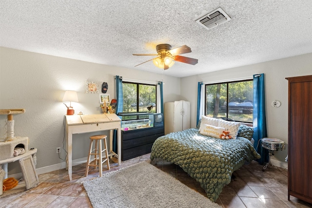 130 Green Acres Loop, Bastrop, TX 78602 - tiled bedroom with baseboards, a textured ceiling, visible vents, and a ceiling fan