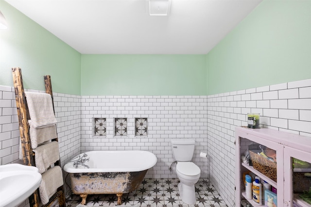 130 Green Acres Loop, Bastrop, TX 78602 - bathroom with toilet, a freestanding tub, tile walls, and wainscoting