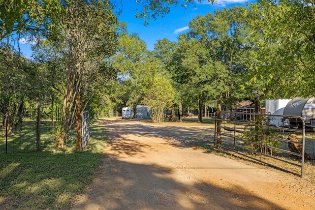 130 Green Acres Loop, Bastrop, TX 78602 - view of road featuring a gated entry and dirt driveway