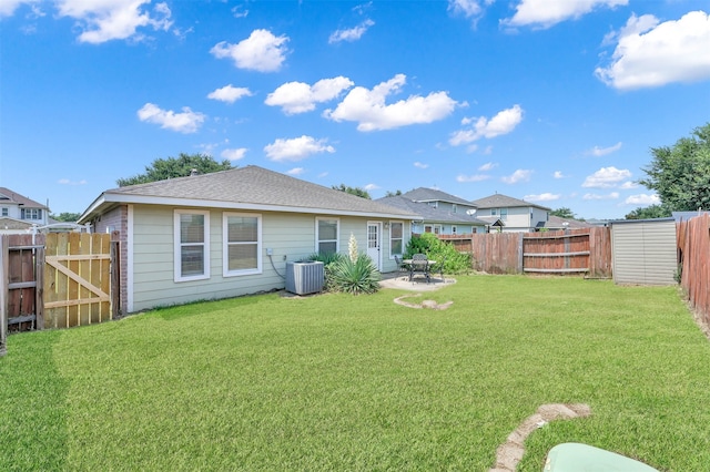 rear view of property featuring a lawn, cooling unit, and a patio area