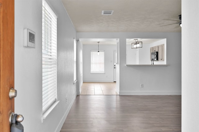 interior space featuring ceiling fan, wood-type flooring, and a textured ceiling