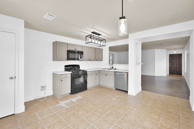 kitchen featuring decorative light fixtures, sink, black appliances, gray cabinetry, and light tile patterned floors