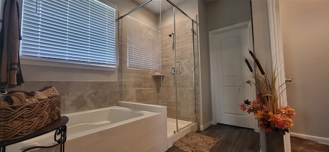 bathroom featuring shower with separate bathtub and wood-type flooring