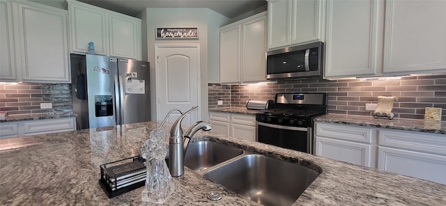 kitchen with decorative backsplash, stone countertops, and appliances with stainless steel finishes