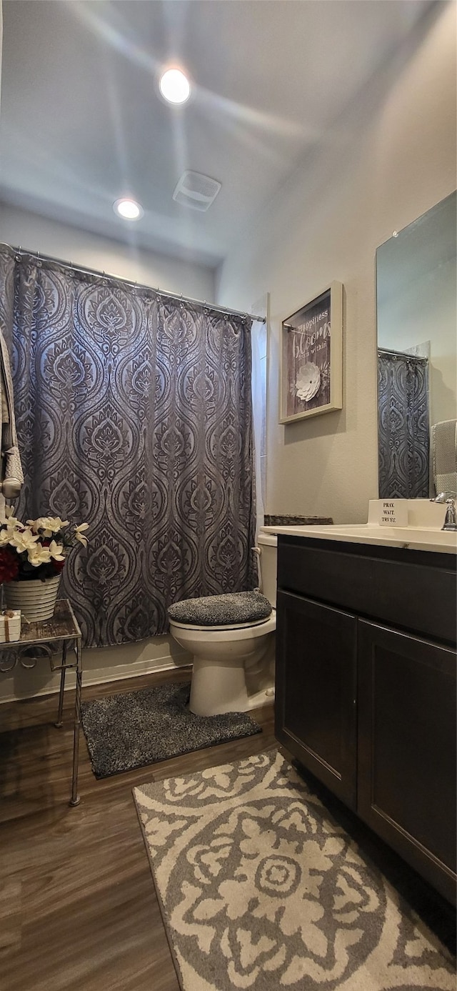 bathroom with hardwood / wood-style flooring, vanity, and toilet