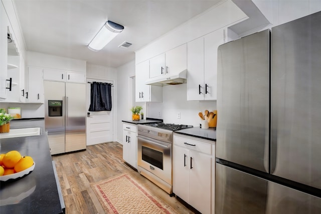 kitchen featuring light wood-type flooring, stainless steel fridge with ice dispenser, white cabinets, stainless steel refrigerator, and range with gas cooktop