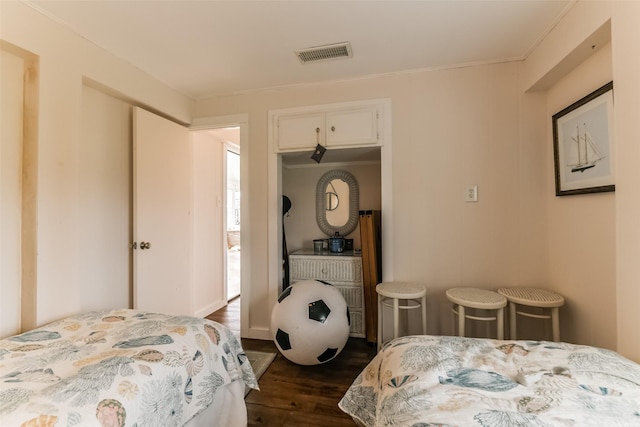 bedroom with dark wood-style floors and visible vents