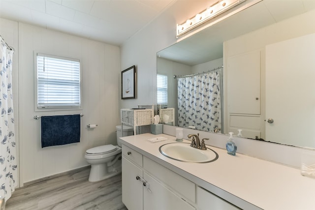 bathroom featuring vanity, a shower with shower curtain, wood finished floors, and toilet