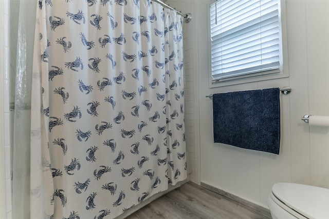 full bath featuring toilet, wood finished floors, and a shower with shower curtain