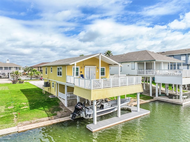 rear view of property featuring a shingled roof, a lawn, boat lift, a residential view, and a water view