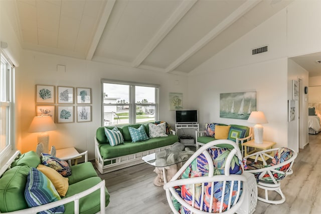 living room featuring lofted ceiling with beams, visible vents, and wood finished floors