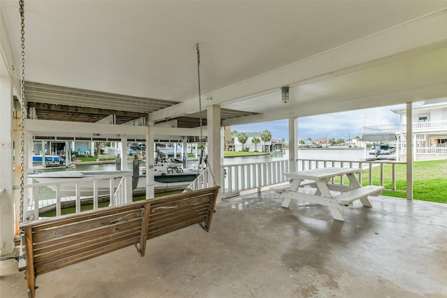 view of patio with a boat dock, a water view, and boat lift