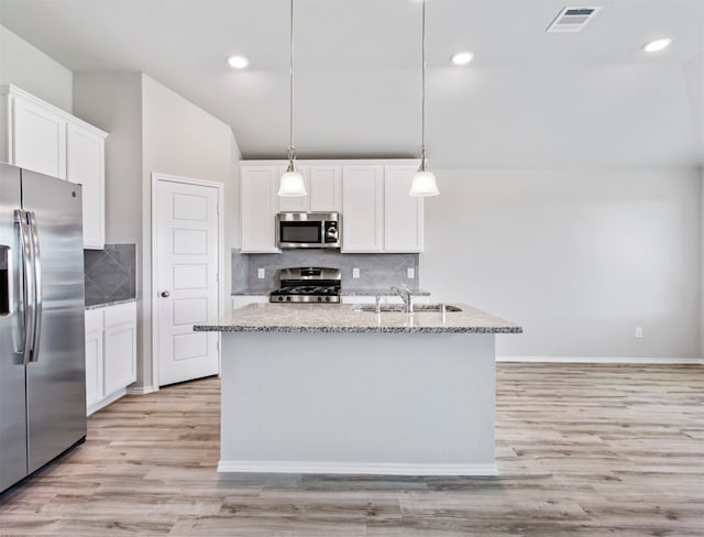 kitchen with decorative light fixtures, light hardwood / wood-style flooring, decorative backsplash, stainless steel appliances, and white cabinets