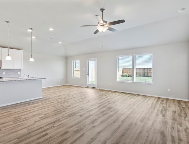 unfurnished living room with a wealth of natural light, light hardwood / wood-style flooring, and ceiling fan