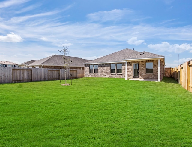 rear view of house featuring a lawn