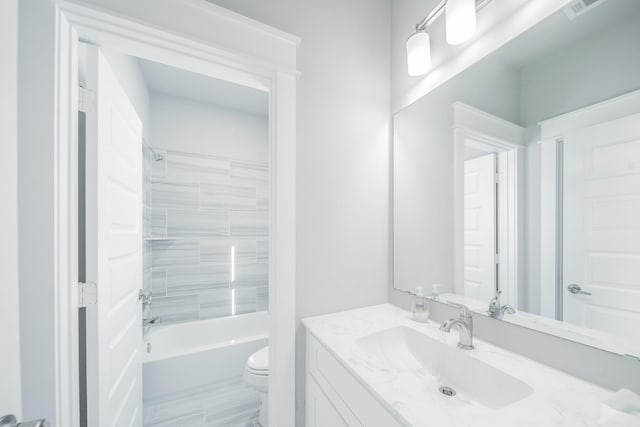 full bathroom featuring toilet, tiled shower / bath, and vanity