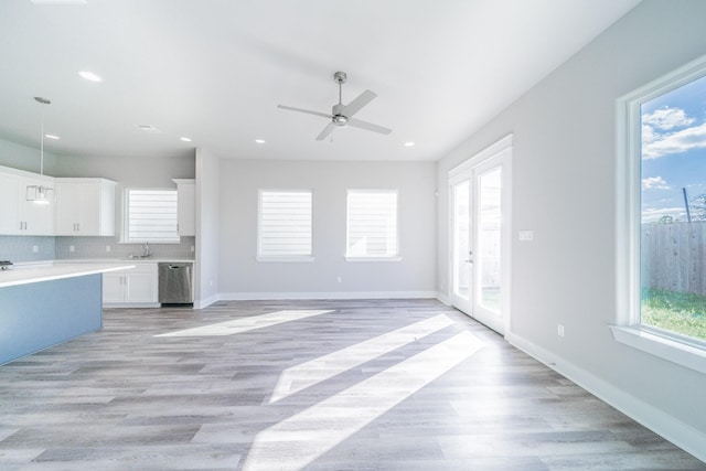 kitchen featuring dishwasher, light hardwood / wood-style floors, decorative backsplash, white cabinetry, and ceiling fan