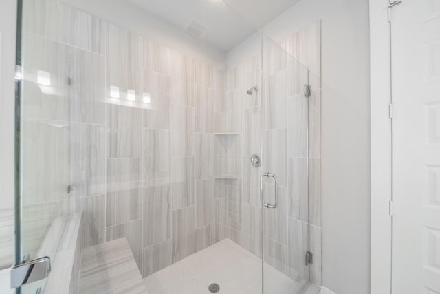 bathroom featuring a shower with door