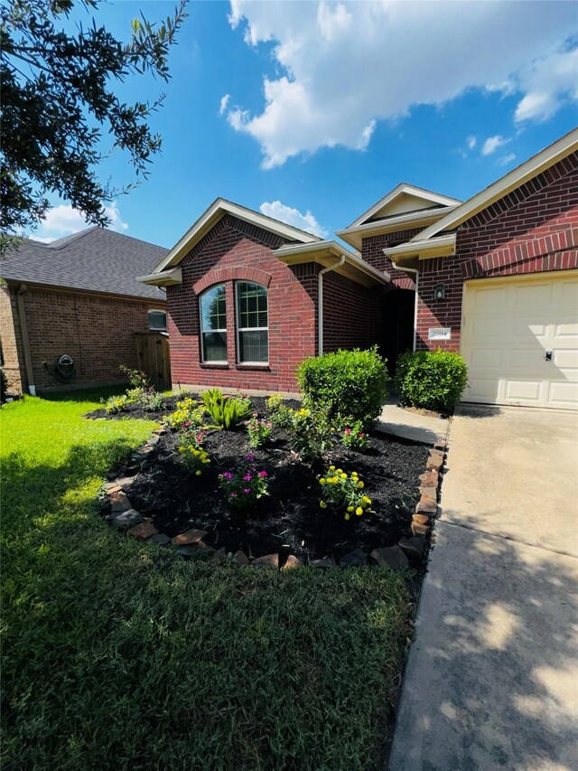 ranch-style home with a garage and a front lawn