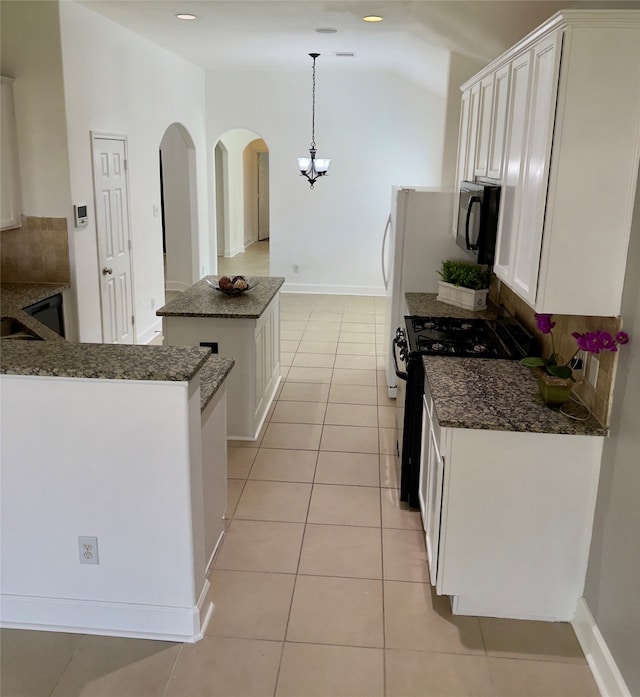 kitchen with gas range oven, white cabinetry, pendant lighting, and a center island