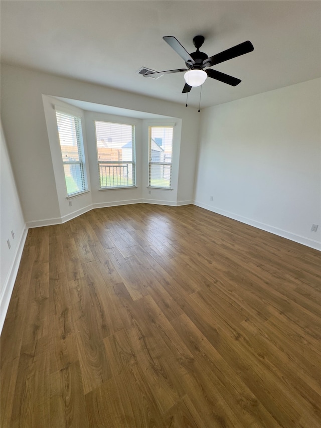 empty room featuring dark wood-type flooring and ceiling fan