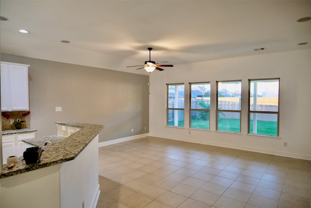 kitchen featuring white cabinets, dark stone counters, and light tile patterned floors