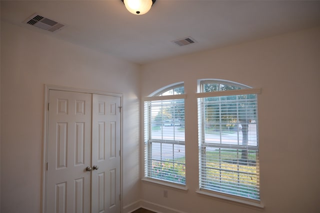 unfurnished bedroom featuring multiple windows and a closet